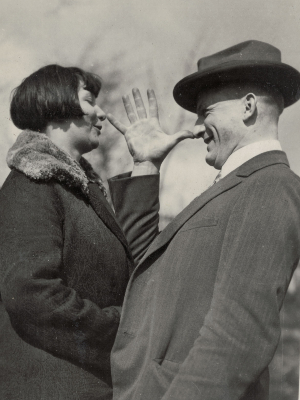 [Translate to Englisch (Intl):] Paar-Foto von Olly und Johannes Wendt im Garten. Beide tragen Mäntel, Johannes außerdem einen Hut. Er zeigt Olly eine "lange Nase".